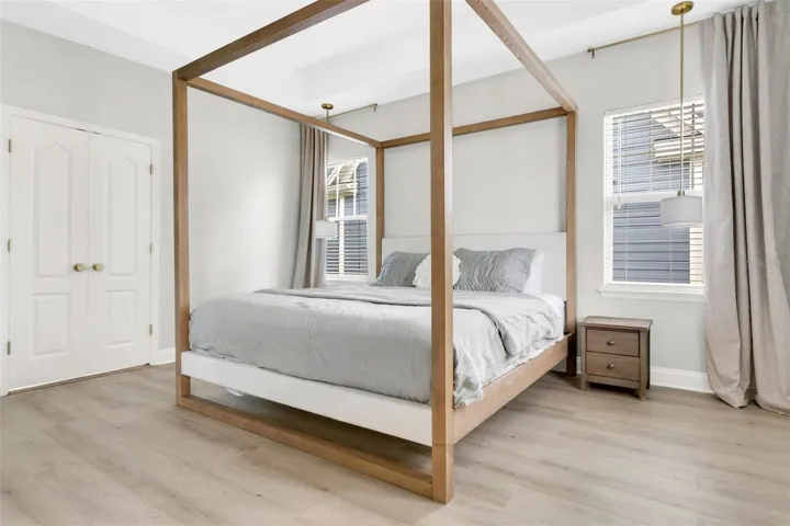 Primary suite offers a private sanctuary, featuring a walk-in closet lined on both sides with custom white cabinetry, multiple drawer banks, and adjustable shelving