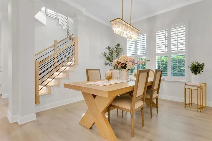 Stylish staircase featuring automatic LED lighting, a light-toned wooden handrail, and sleek horizontal black metal infill bars