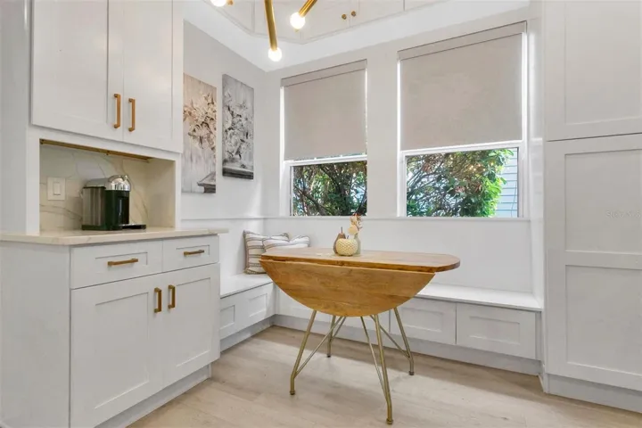 A thoughtfully redesigned breakfast nook completes the kitchen layout, offering an L-shaped banquette bench with built-in storage and a dedicated coffee bar.