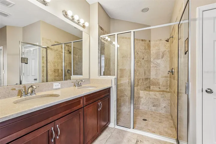Primary Bathroom with dual vanity, soaking tub, walk in shower and 2 walk in closets