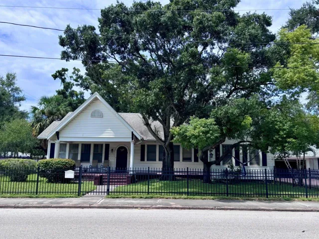Peaked roof, arched doorway, columns and a paver front porch. Photo from 2024