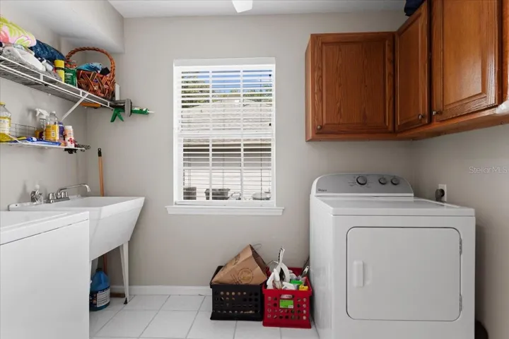 You will love this over-sized laundry room with sink and storage shelving.