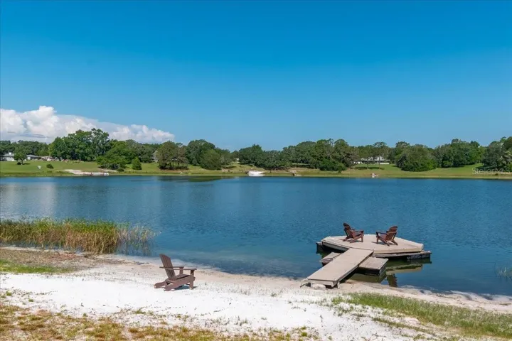 Private lakefront oasis featuring a sandy beach, private dock, and panoramic water views.