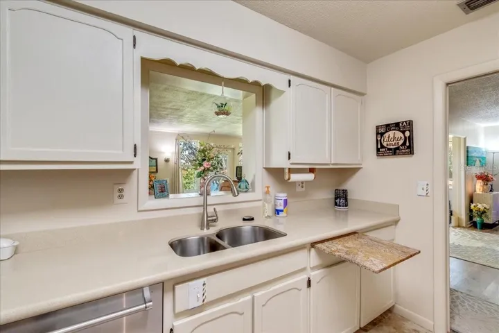 Quality craftsmanship shines throughout the kitchen with durable quartz countertops, a convenient built-in cutting board, ample workspace, the pass-through above the sink allows natural light to flow through the space while offering peaceful views toward the lake, making even everyday tasks more enjoyable.