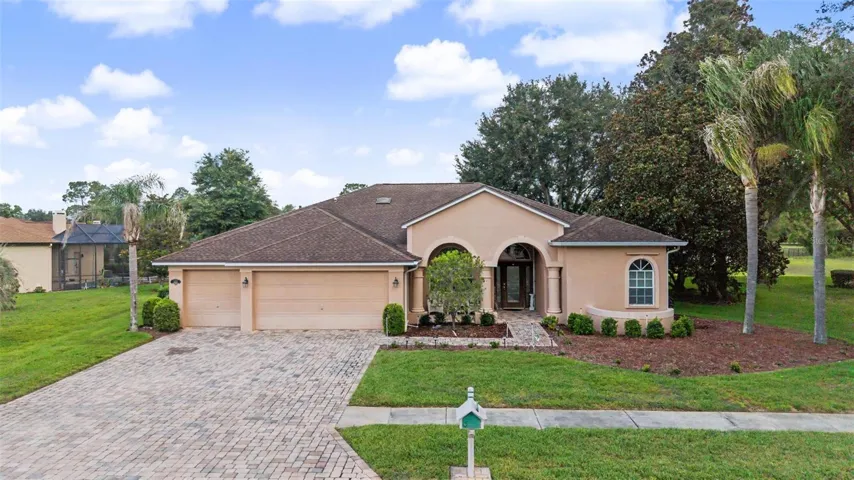Welcome home to this beautifully maintained residence in Silverthorn Golf & Country Club. The inviting curb appeal features lush tropical landscaping, mature palm trees, a paver driveway, and a spacious three-car garage, creating a stunning first impression from the moment you arrive.