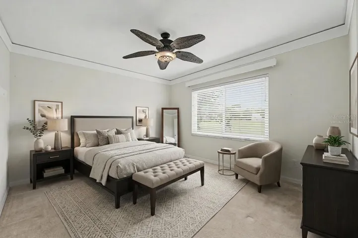 Spacious Secondary Master bedroom, virtually staged with a king-size bed to showcase the room’s generous scale and layout. The space features abundant natural light, plantation shutters, and detailed baseboards, highlighting its comfort and versatility as one of the four bedrooms in the home.