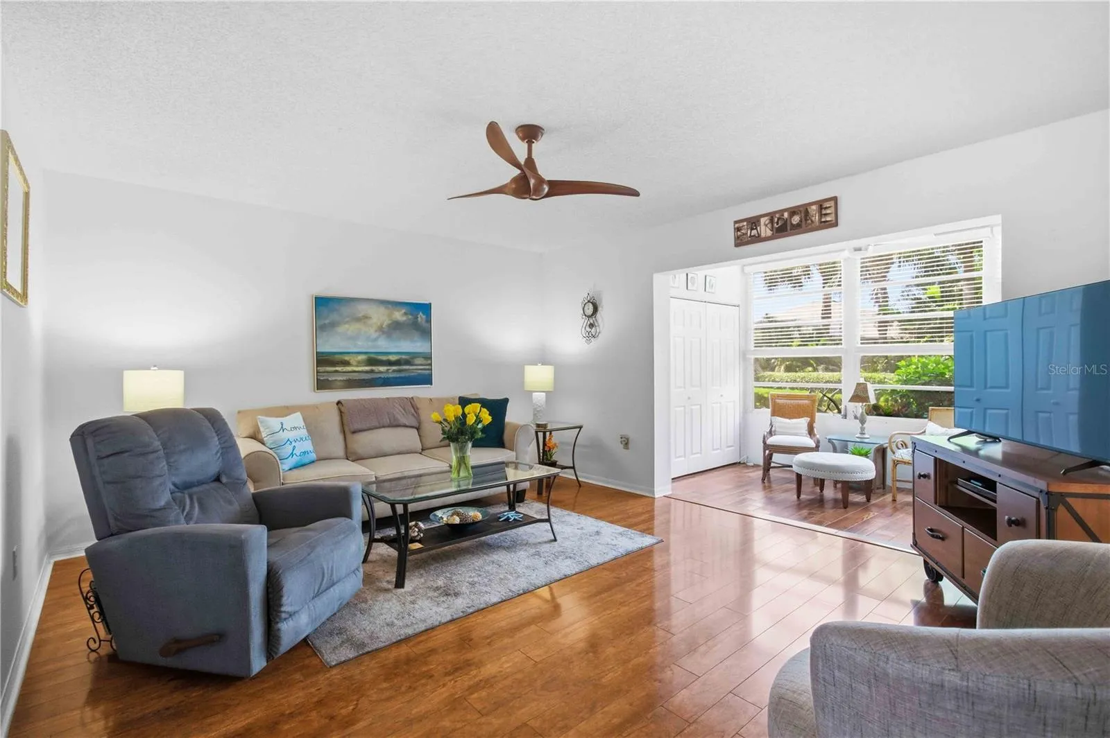 Light and Bright living room overlooking enclosed lanai space and greenspace.