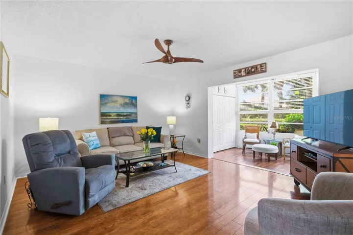 Light and Bright living room overlooking enclosed lanai space and greenspace.