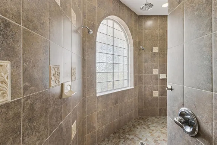 Walk in shower with dual wall mounted showerheads and an overhead rain shower