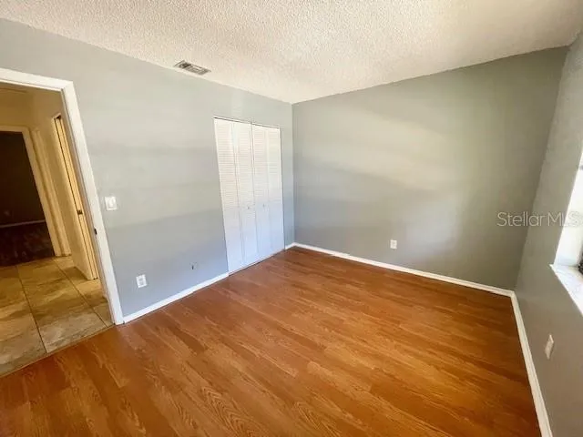 Guest bedroom with vinyl flooring and built in closet.