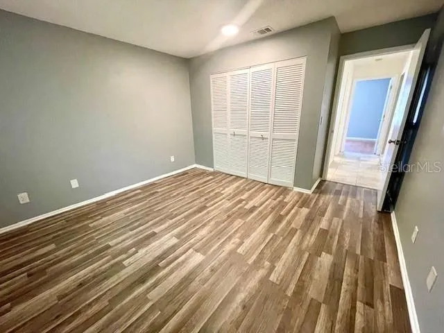 Sizable primary bedroom with vinyl flooring and built in closet.