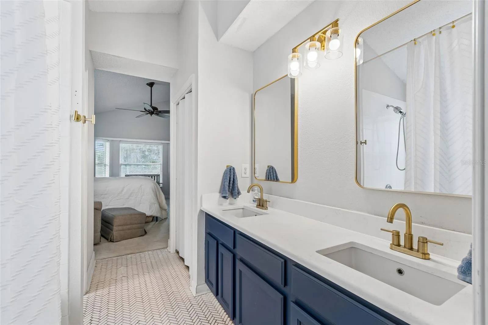 Primary bath with quartz counters and herringbone tilework