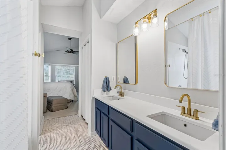 Primary bath with quartz counters and herringbone tilework