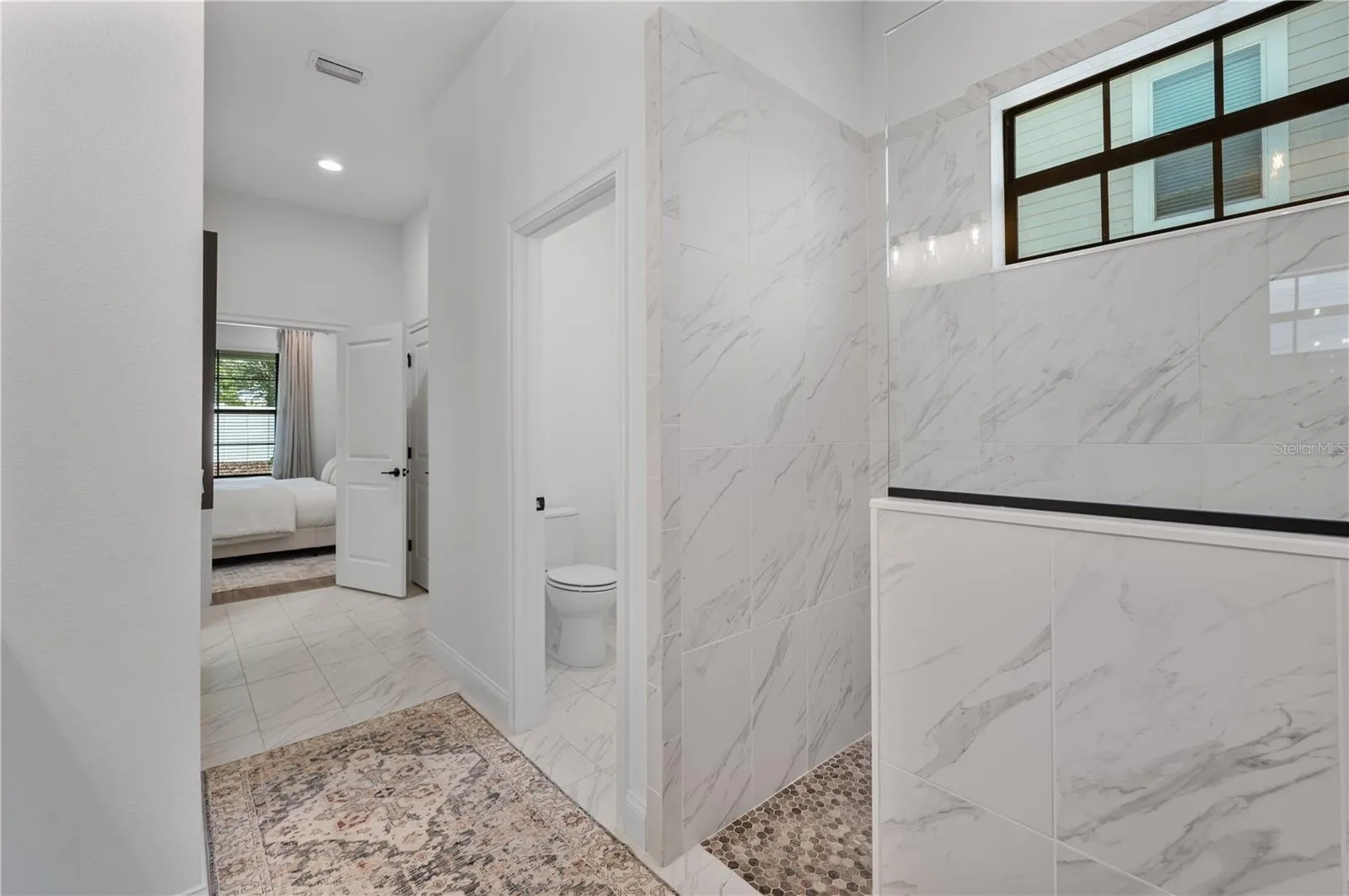 Primary ensuite bathroom with private toilet closet