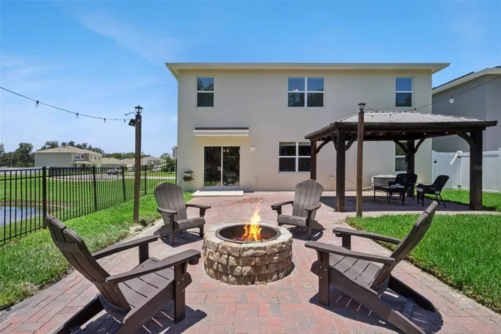 Fire pit, gazebo,large paved patio facing pond on one side and partially wooded on the other side