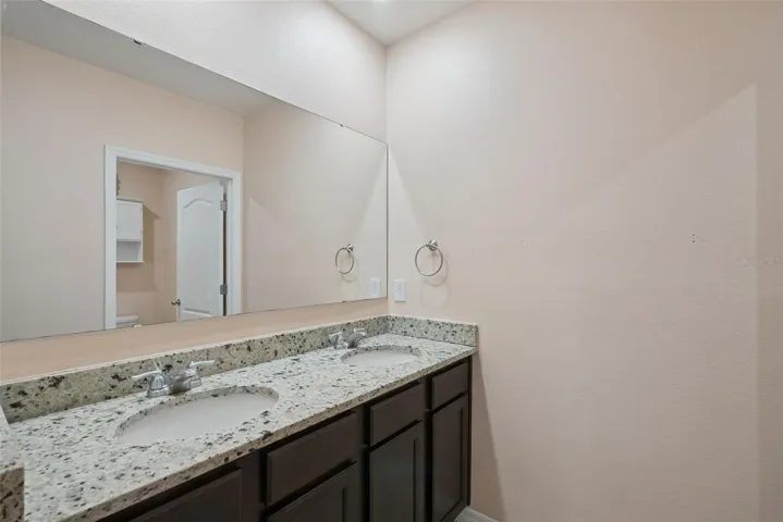 Upstairs full bathroom with dual sinks and shower