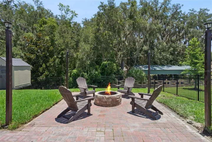 Fire pit, gazebo,large paved patio facing pond on one side and partially wooded on the other side
