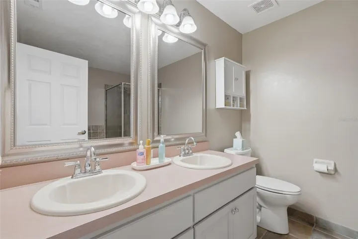 Ensuite with step in shower, dual vanity, and soaking tub
