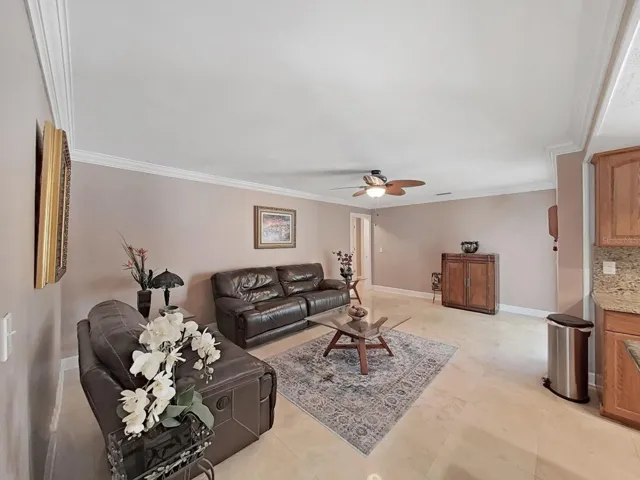 Beautiful crown molding and Travertine floors accentuate this large Family room. Its also great for a larger dining table and buffet or pool table!
