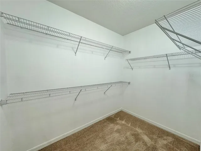 Primary walk-in closet *Vinyl plank flooring CURRENTLY being installed*