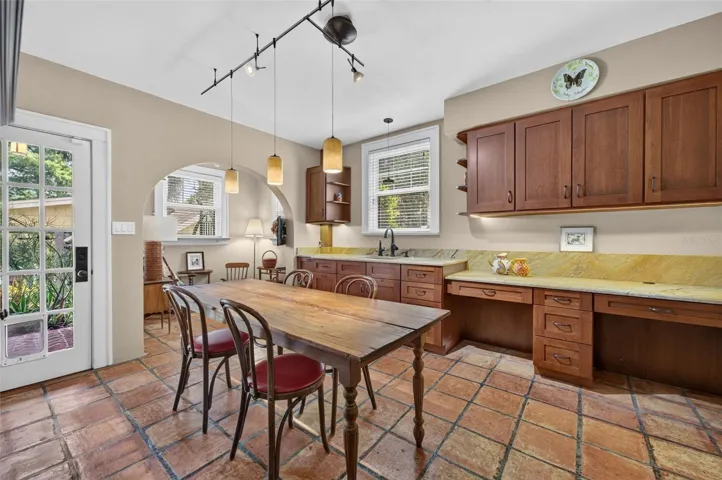 Former full kitchen on lower level offers wet bar/dining area plus cozy sitting area in alcove. Leads to finished basement, laundry room, expansive storage and driveway entry door