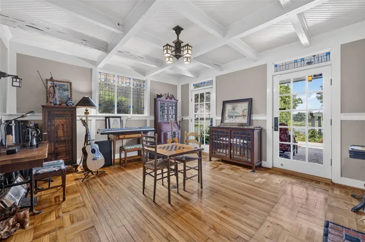 Lower level living room leads to wet bar and summer dining room. French doors to lanai, summer kitchen, and outdoor living spaces