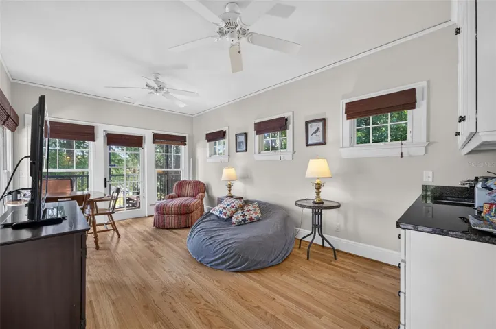 Living room and kitchenette in guest house situated under the trees with screened porch on lake