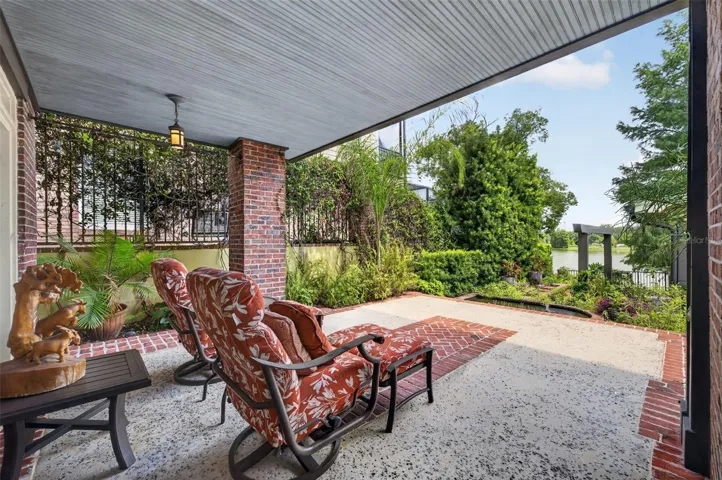 Sitting area lanai overlooking terraced backyard with water feature; fountains and waterfalls flow peacefully to lake