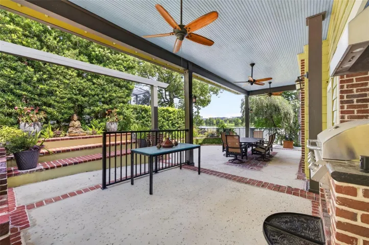 Summer kitchen with grill, fireplace, prep area and dining space adjacent to guest house