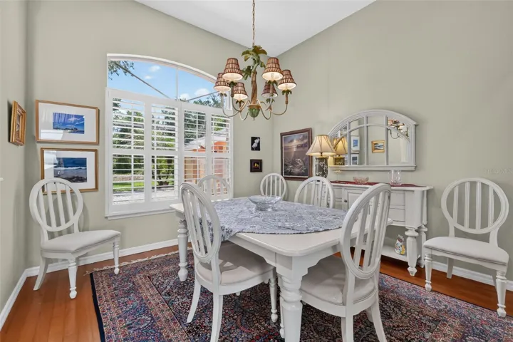 Dining room with wood floors and Plantation shutters