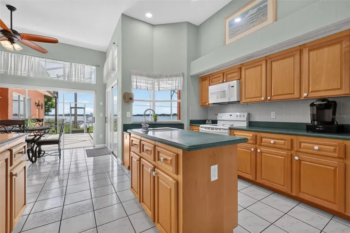 Kitchen has a great layout with center prep island w/sink, and pass through window to pool wet bar