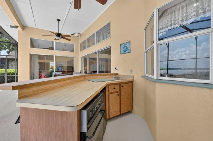 Wet bar on pool deck; kitchen window just behind for ease of entertaining.