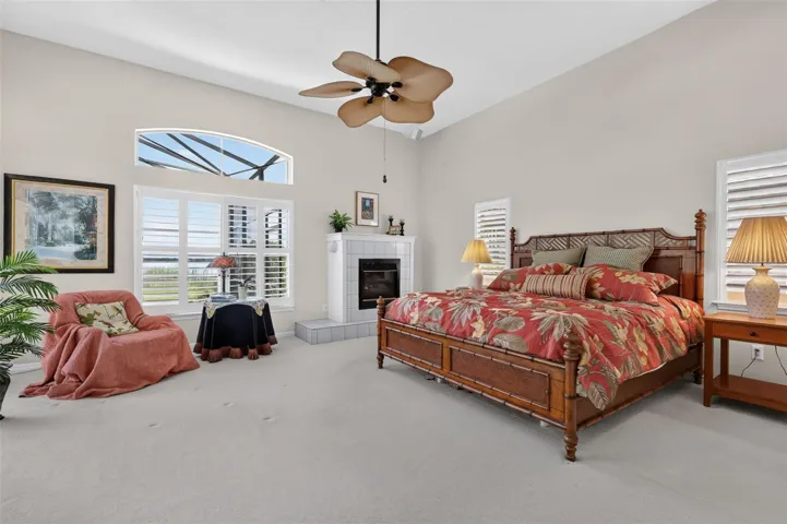 Primary bedroom with high ceilings, Planation shutters, cozy fireplace and views of Lake Dora