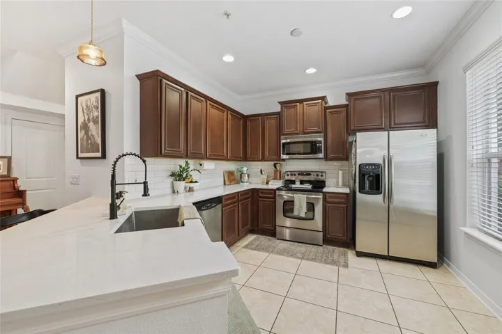stunning cabinets, recessed lighting, backsplash, farmhouse sink, and stainless steel appliances
