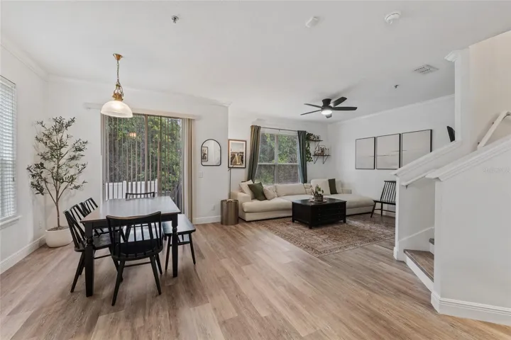 Spacious family room featuring laminate flooring, ceiling fan, blinds and so much natural light coming in through windows and slider.