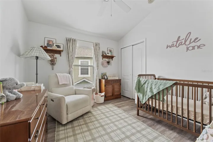 Bedroom 2 featuring laminate flooring, ceiling fan, blinds