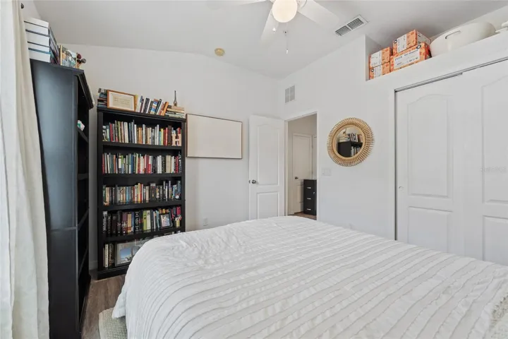 Bedroom 3 featuring laminate flooring, ceiling fan, blinds additional storage area over closet