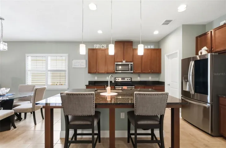 Kitchen features pendant lighting over the island with counter seating