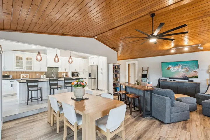 Open living, dining, and remodeled kitchen layout with vaulted wood ceilings and updated finishes.