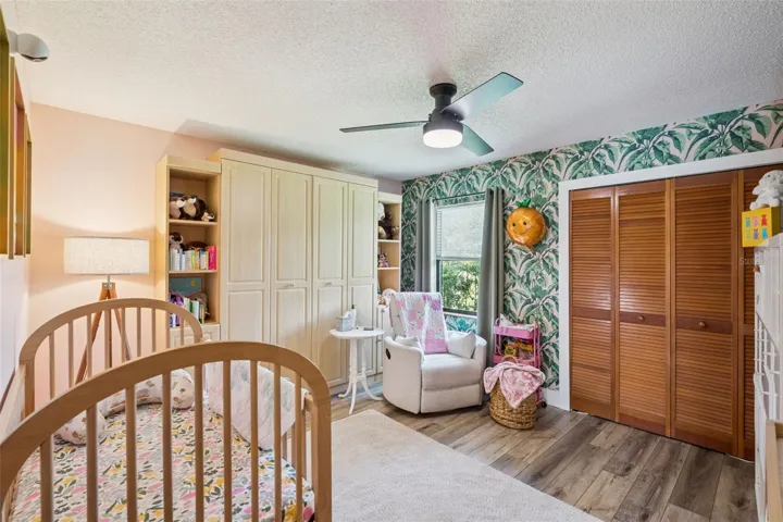Additional bedroom with natural light, ceiling fan, and comfortable layout.