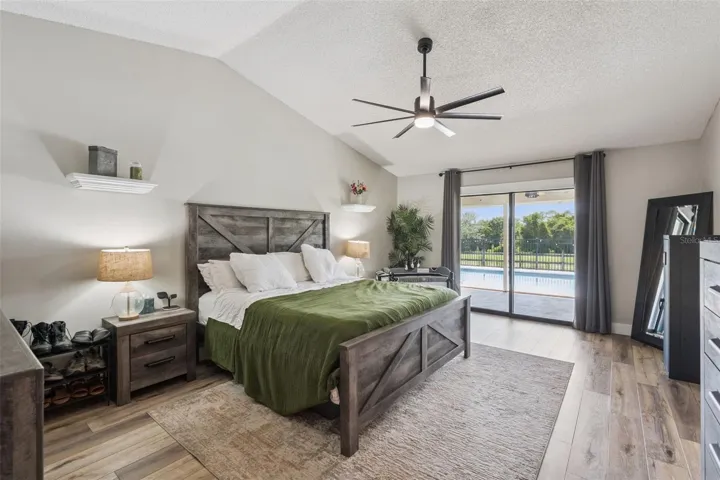 Primary suite with room for large furniture, updated flooring, and direct access to outdoor living.