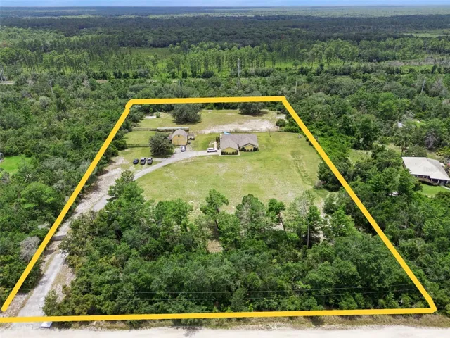 Front exterior of 1740 Cypress Ave in Orange City, FL, a 3 bedroom, 2 bathroom pool home with gated entrance on 5 acres with barn and workshop.