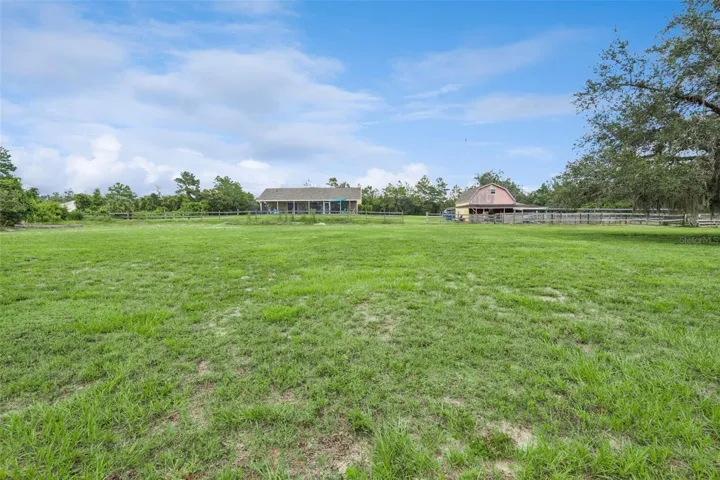 Wide eastward view of the fenced acreage previously used as a riding arena.