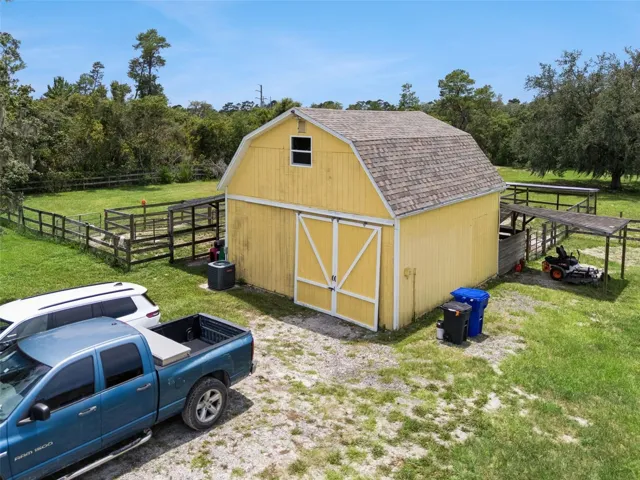Detached barn with storage, air conditioned workshop space, stables, dog runs, and flexible utility areas.