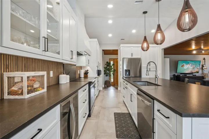 Kitchen detail with granite counters, backsplash, cabinetry storage, and functional prep space.