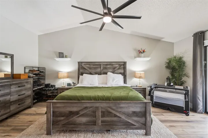 Primary bedroom view with neutral finishes, ceiling fan, and spacious layout.