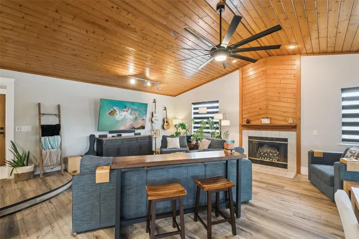 Open family room and dining area with warm ceiling detail, updated flooring, and natural light.