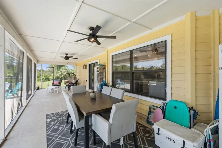 Screened lanai with covered seating area, pool views, and direct access from the home.