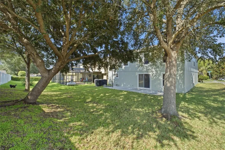 Back of home with mature trees