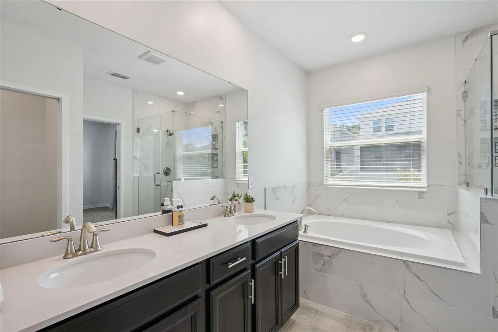 Primary bath with dual sinks, tub, and separate shower